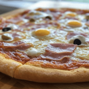 Pizza Pizzaïolo de Pizza Mania à Saint-Yrieix-la-Perche avec jambon, œuf, crème fraîche, olives et fromage fondant.