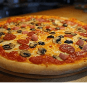 Pizza Réale de Pizza Mania à Saint-Yrieix-la-Perche avec jambon, chorizo, champignons, olives et fromage fondant.