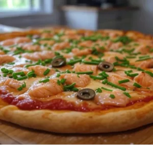 Pizza Saumon de Pizza Mania à Saint-Yrieix-la-Perche avec saumon, ciboulette, crème fraîche, olives et fromage fondant.