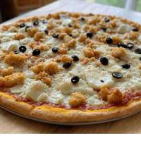 La Poulet Curry chez Pizza Mania à Saint-Yrieix-la-Perche - une pizza crémeuse et épicée avec poulet mariné, lait de coco et olives.